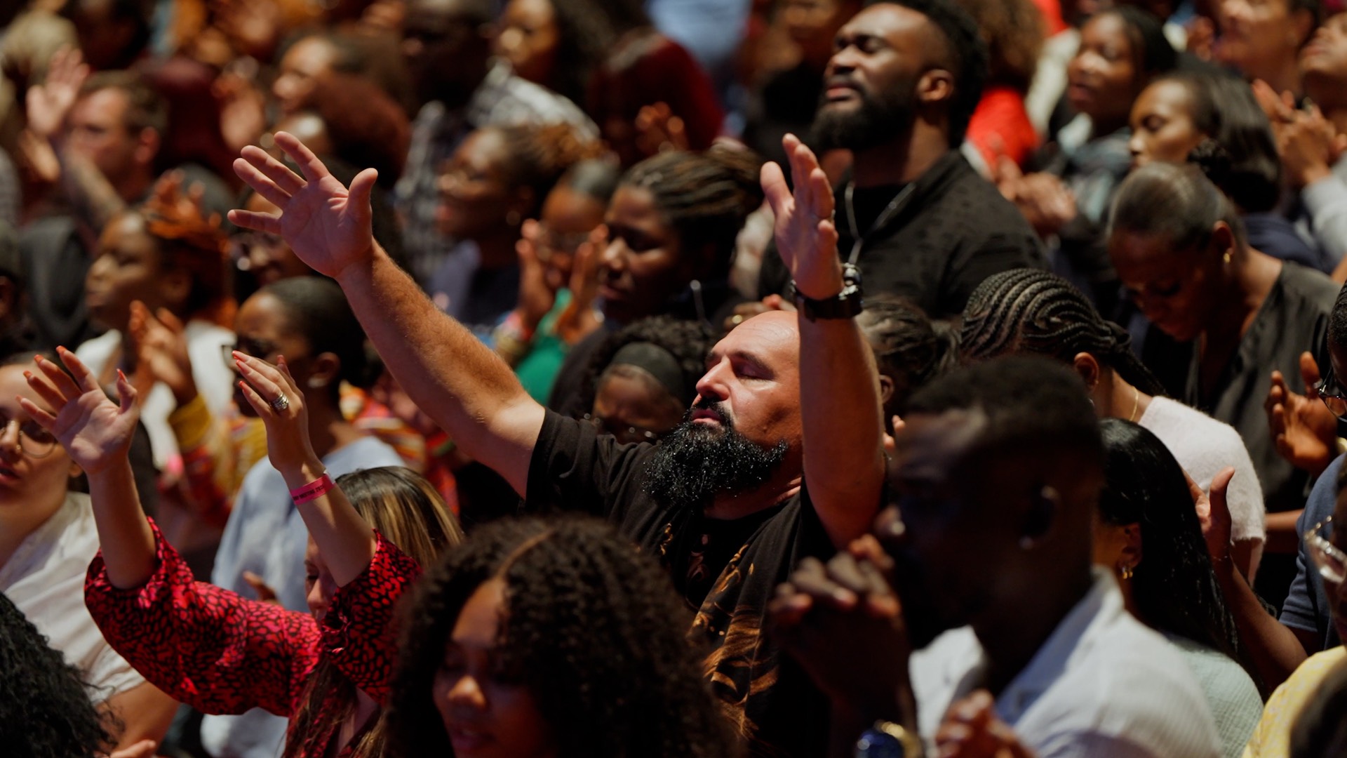 Healing crusade attendees lifting hands in worship at Night of Glory